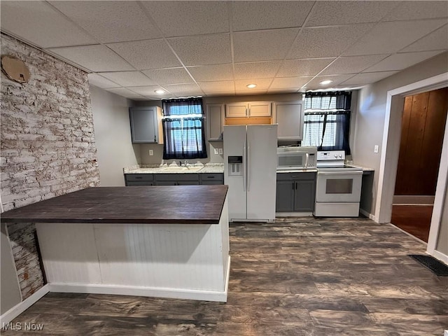 kitchen featuring sink, white appliances, gray cabinetry, a drop ceiling, and wood counters