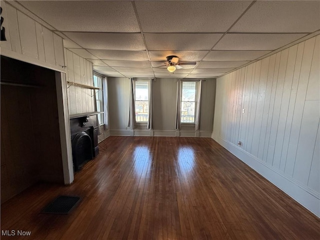 unfurnished living room with ceiling fan, a paneled ceiling, and dark hardwood / wood-style flooring