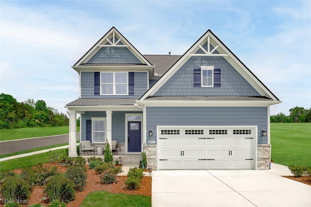 craftsman-style house with a garage, a front yard, and a porch