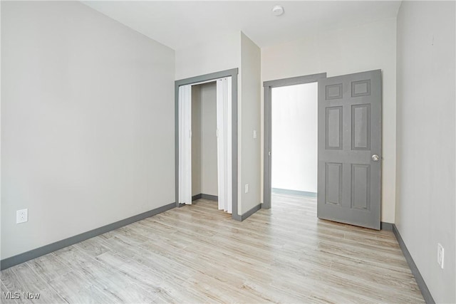 unfurnished bedroom featuring light hardwood / wood-style floors and a closet