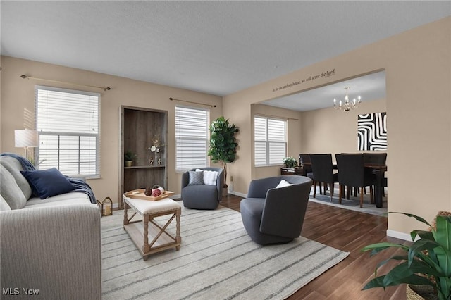 living room with hardwood / wood-style flooring, a textured ceiling, a chandelier, and a healthy amount of sunlight