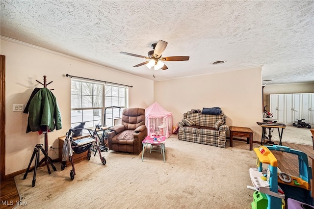 playroom with a textured ceiling, ceiling fan, and carpet flooring