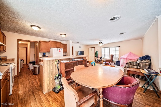 dining room with dark wood-type flooring, ceiling fan, and a textured ceiling