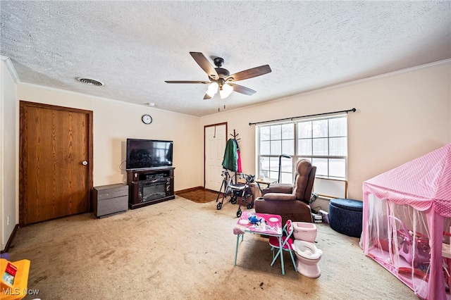 playroom with ornamental molding, carpet floors, a textured ceiling, and ceiling fan