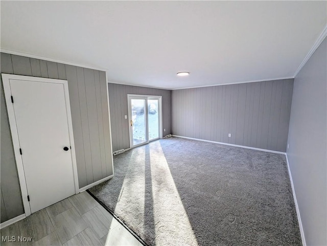 carpeted empty room featuring crown molding