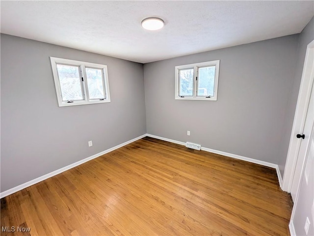 unfurnished room featuring light hardwood / wood-style flooring and a wealth of natural light