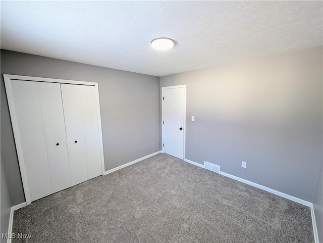 unfurnished bedroom with a closet, carpet, and a textured ceiling