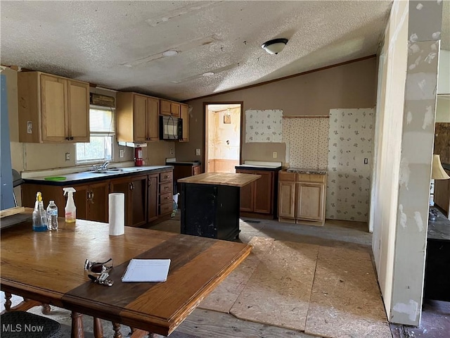 kitchen featuring lofted ceiling, sink, a textured ceiling, and a kitchen island