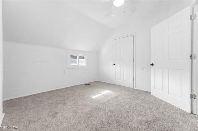 additional living space featuring carpet floors, ceiling fan, and vaulted ceiling