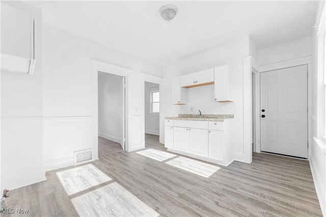 kitchen with white cabinetry and light hardwood / wood-style flooring