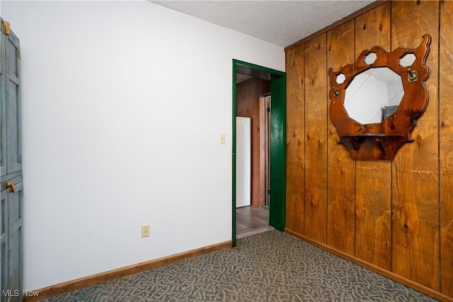 interior space with dark colored carpet and a textured ceiling