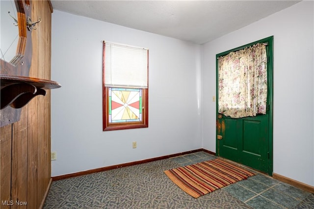 entrance foyer with dark colored carpet