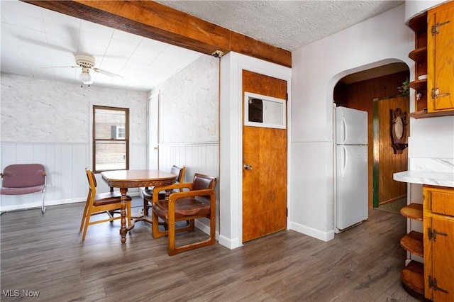 dining space with dark wood-type flooring, a textured ceiling, and ceiling fan