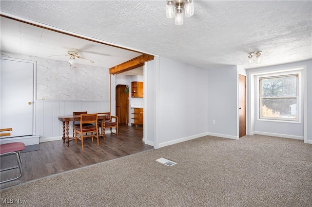 dining room featuring ceiling fan, a textured ceiling, and dark carpet