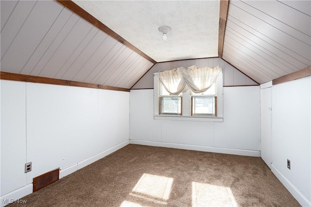 additional living space featuring vaulted ceiling and carpet flooring