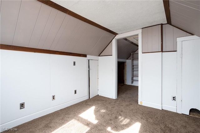 additional living space featuring lofted ceiling, a textured ceiling, and carpet