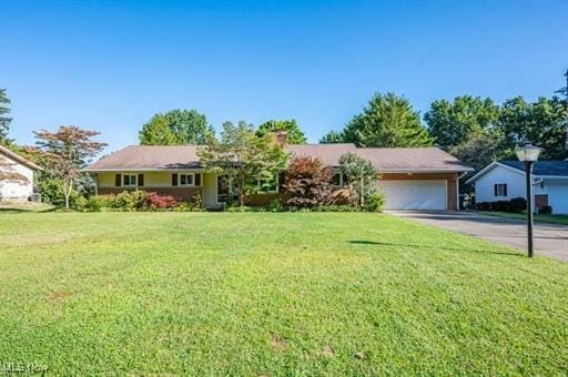 ranch-style house featuring a garage and a front yard