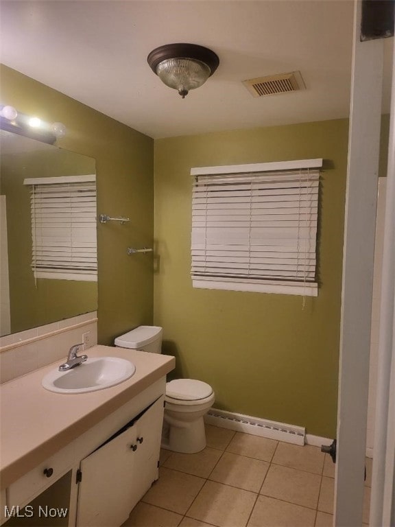 bathroom featuring tile patterned flooring, vanity, a baseboard heating unit, and toilet