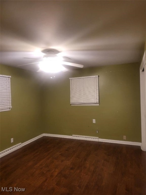 spare room featuring ceiling fan, a baseboard radiator, and dark hardwood / wood-style flooring