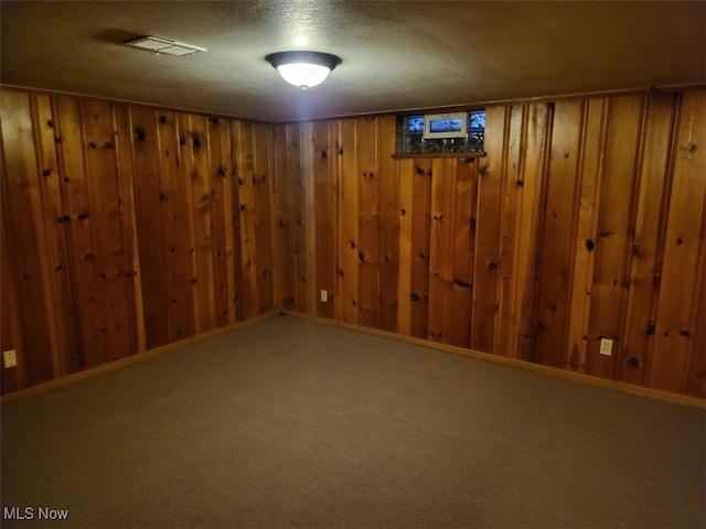 basement with carpet flooring and wood walls