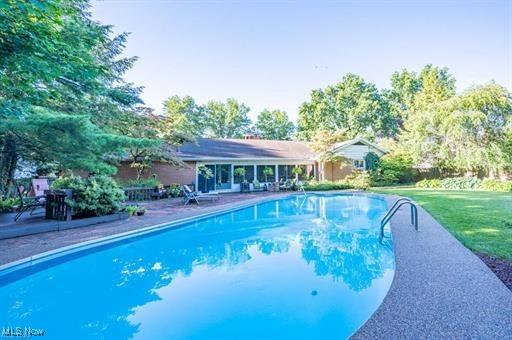 view of pool featuring a lawn