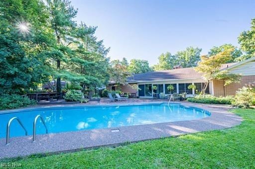 view of swimming pool featuring a yard