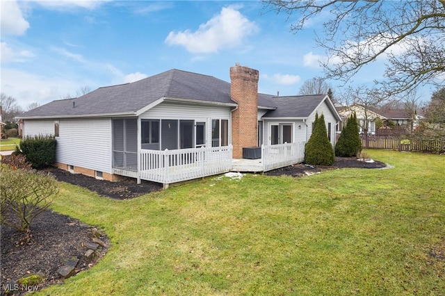 rear view of property featuring a deck and a lawn