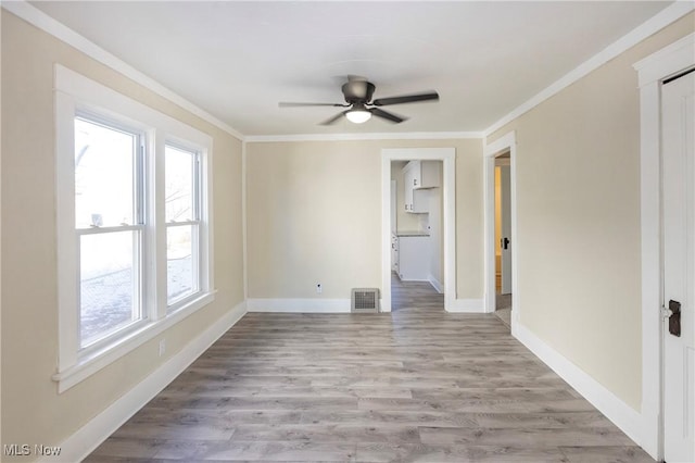 unfurnished room featuring crown molding, ceiling fan, and light wood-type flooring