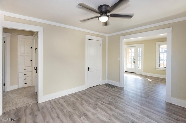 empty room featuring ornamental molding, ceiling fan, and light hardwood / wood-style floors