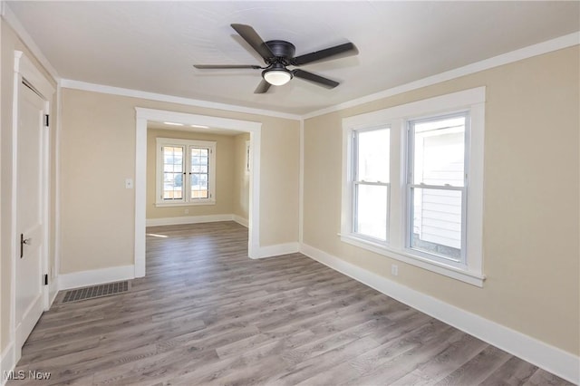 spare room featuring ornamental molding, ceiling fan, and light wood-type flooring