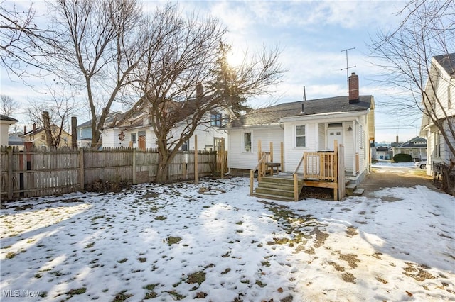 view of snow covered rear of property