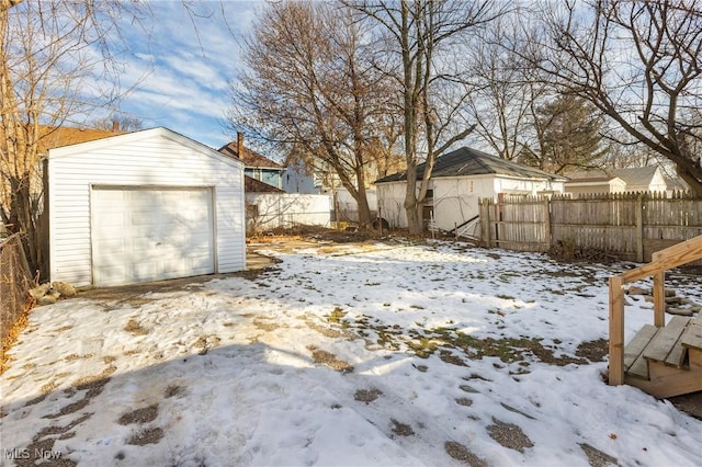 yard covered in snow with a garage and an outdoor structure