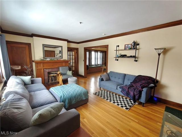 living room with a brick fireplace, crown molding, and wood-type flooring