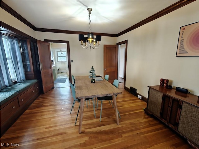 dining area featuring hardwood / wood-style floors, a notable chandelier, and ornamental molding