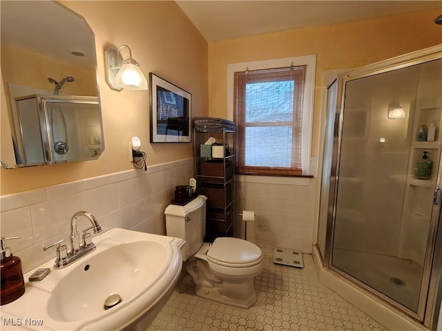 bathroom with sink, tile walls, an enclosed shower, and toilet