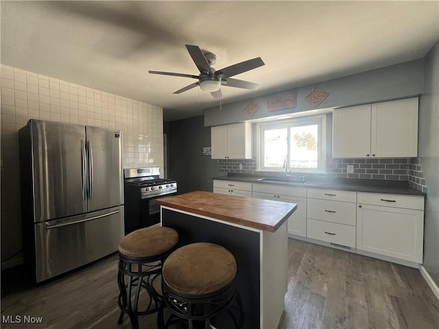 kitchen with white cabinetry, stainless steel appliances, a center island, and sink