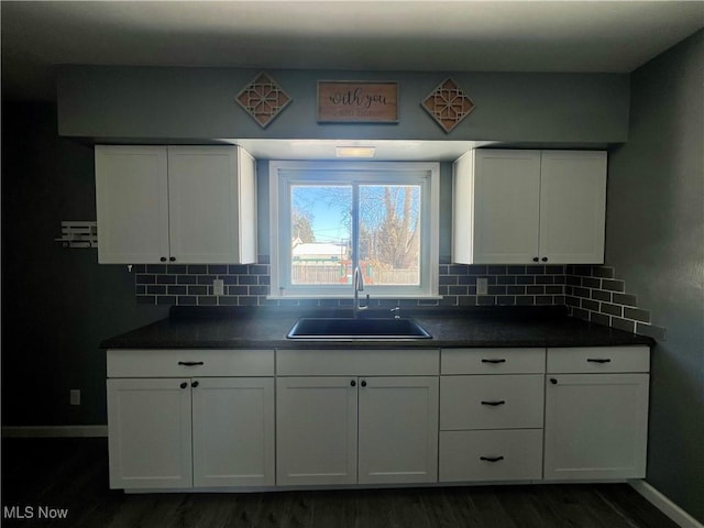 kitchen featuring sink, white cabinets, and backsplash