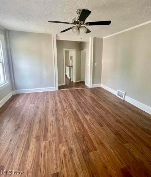 unfurnished room featuring ceiling fan, dark hardwood / wood-style floors, and a textured ceiling