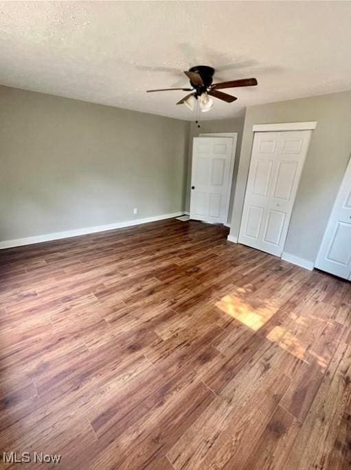 unfurnished bedroom with ceiling fan, hardwood / wood-style floors, a closet, and a textured ceiling