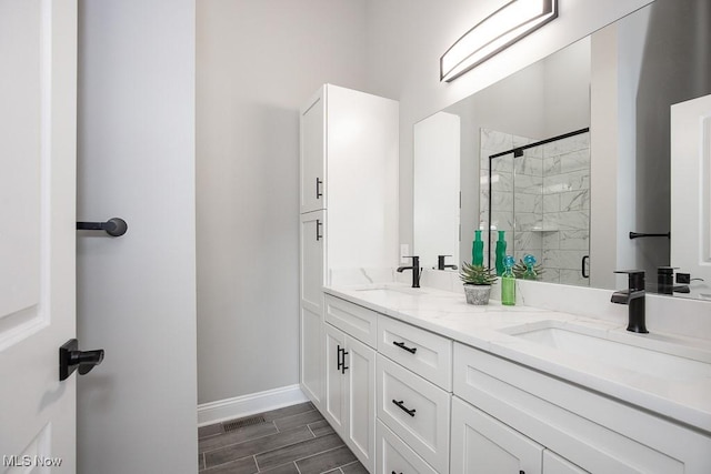 bathroom with a shower with door and vanity