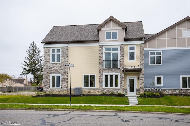 view of front of property with cooling unit and a front yard