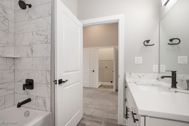 bathroom featuring tiled shower / bath combo and vanity