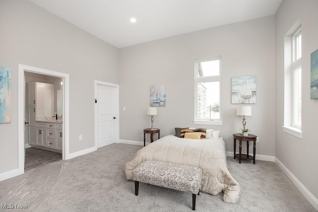 bedroom featuring light colored carpet and connected bathroom