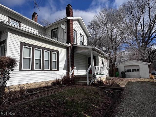 view of property exterior featuring an outbuilding, a garage, and a porch