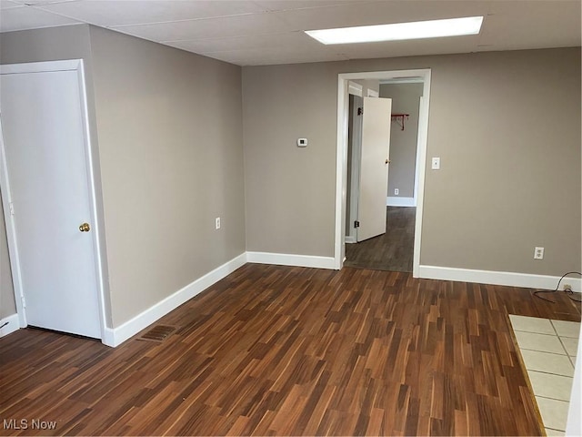 unfurnished room with dark hardwood / wood-style flooring