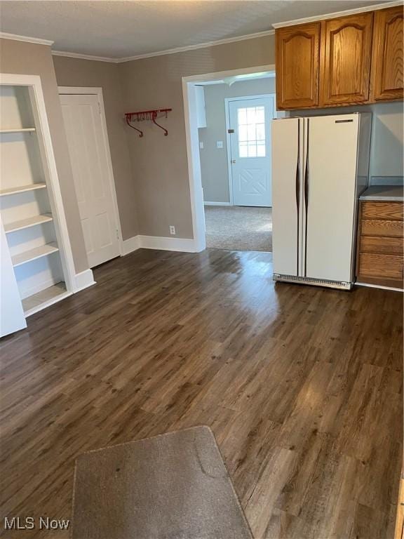 interior space featuring built in shelves, ornamental molding, dark hardwood / wood-style floors, and white fridge