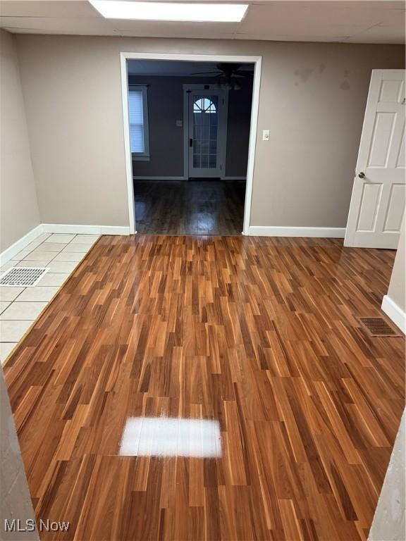 spare room featuring dark hardwood / wood-style floors and a paneled ceiling