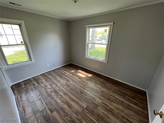 empty room with ornamental molding and dark hardwood / wood-style floors