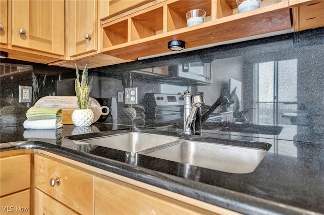 details with tasteful backsplash, sink, and dark stone counters