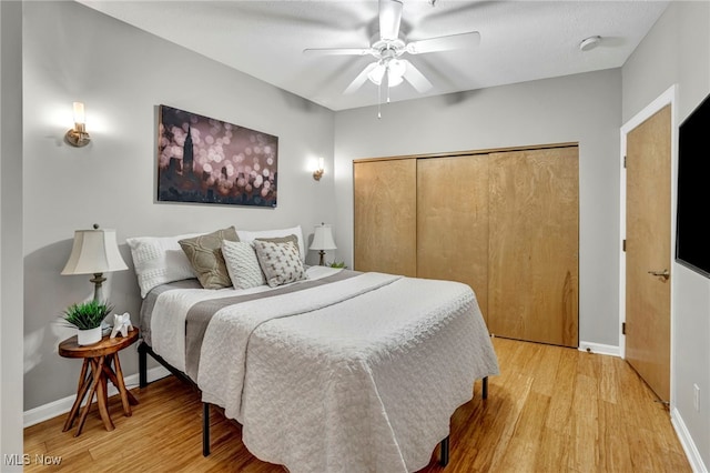 bedroom featuring light hardwood / wood-style floors, a closet, and ceiling fan